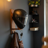 Handcrafted wooden helmet holder mounted in garage with motorcycle helmet
